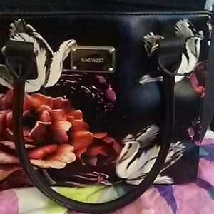 Its a Nine Wesr black purse with flowers on the fr